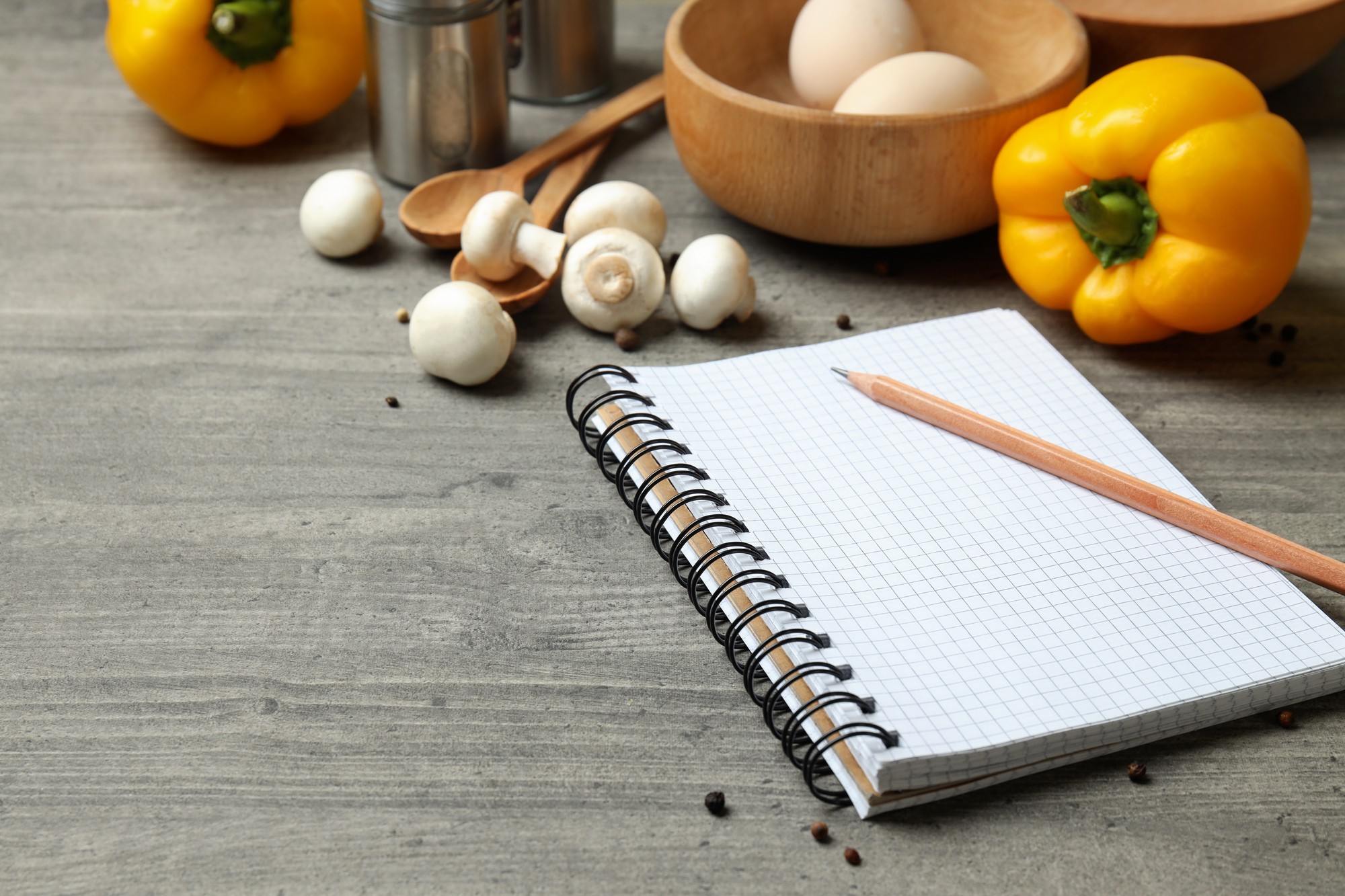 Studijos stalviršis su ingredientais ir atversta užrašų knygele